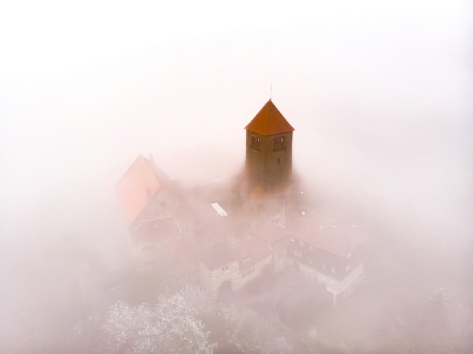 a castle in the middle of a foggy forest